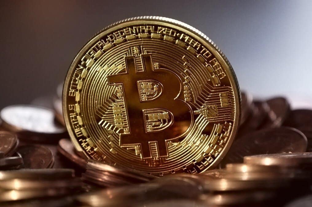 Sikkələr yığınının üstündə bitcoin simvolu olan qızıl sikkə