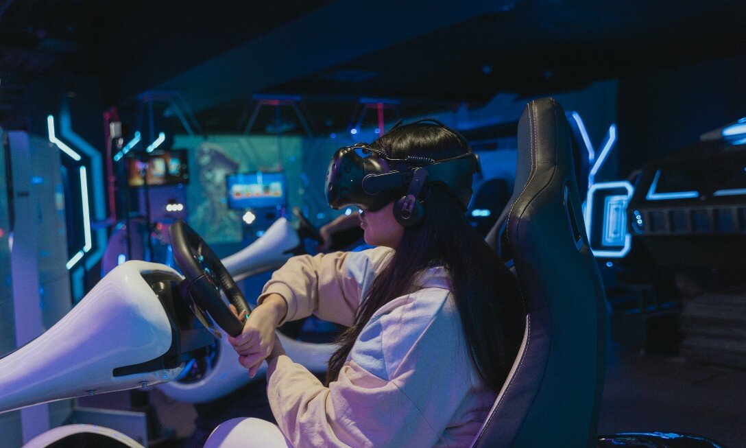 Girl in VR goggles in driving simulator