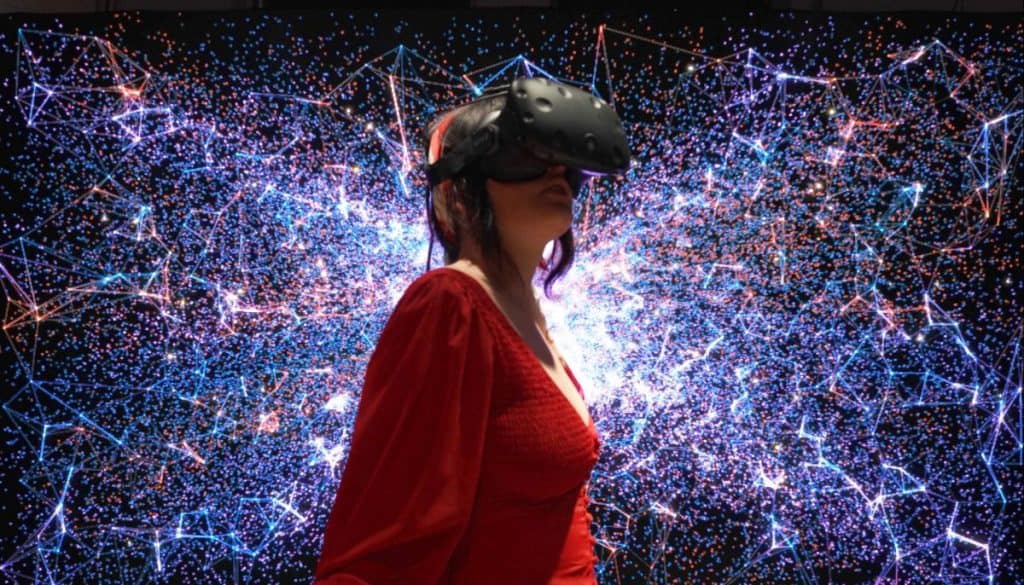 Woman wearing a VR goggle in colorful environment
