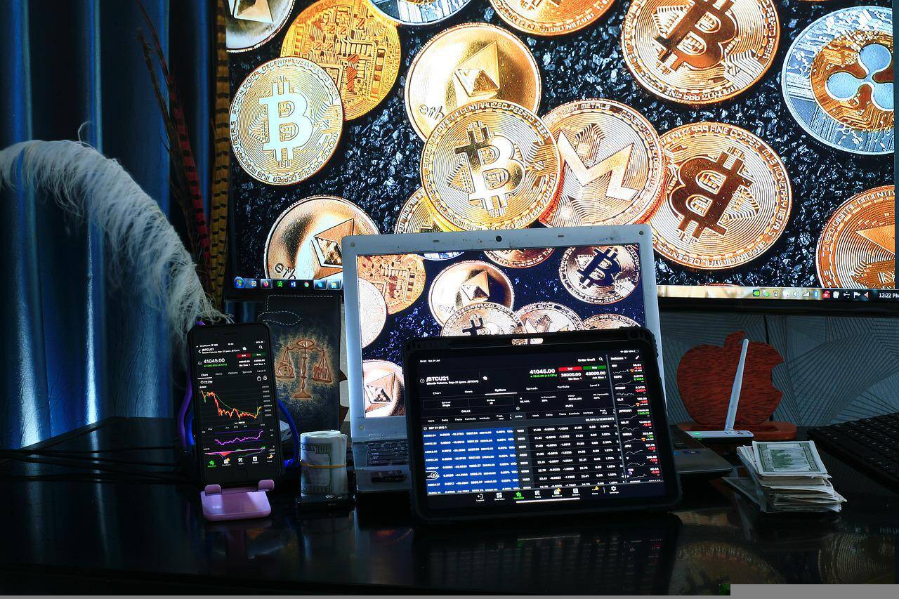 Display of cryptocurrency trading station including coin symbols and laptop computers